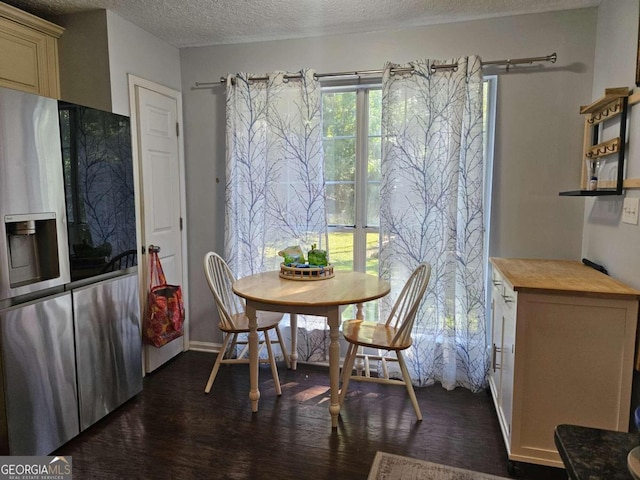 dining room with dark wood-type flooring and a textured ceiling