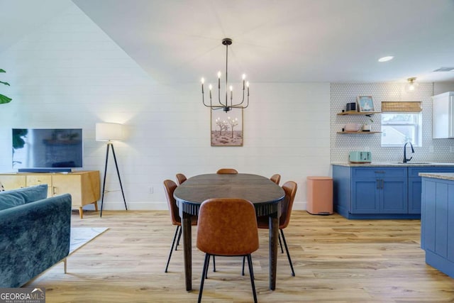 dining room featuring light hardwood / wood-style floors, a notable chandelier, and sink