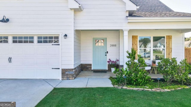 doorway to property featuring a lawn and a garage