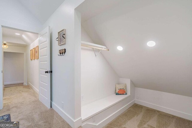 interior space featuring carpet flooring and vaulted ceiling