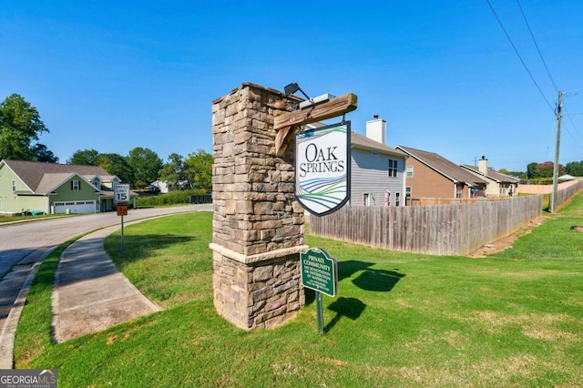 community sign with a garage and a yard