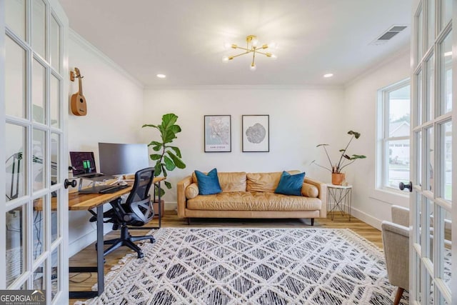 home office featuring light hardwood / wood-style floors, a healthy amount of sunlight, french doors, and crown molding