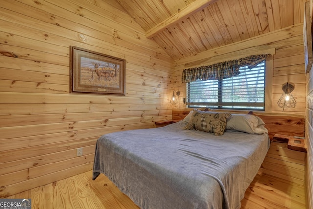 bedroom featuring lofted ceiling with beams, wooden walls, light wood-type flooring, and wood ceiling