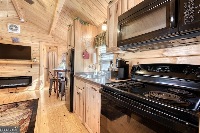 kitchen featuring black appliances, light brown cabinetry, and lofted ceiling with beams