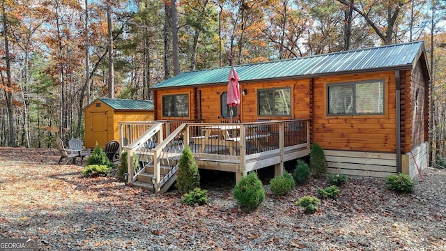 view of front of property with a shed and a wooden deck