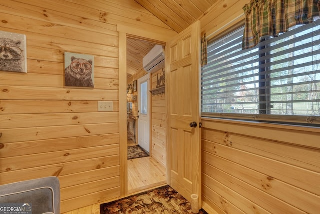 entryway with wood walls, a wall mounted AC, hardwood / wood-style floors, wood ceiling, and vaulted ceiling