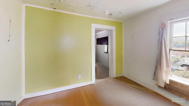 spare room with hardwood / wood-style floors and a textured ceiling