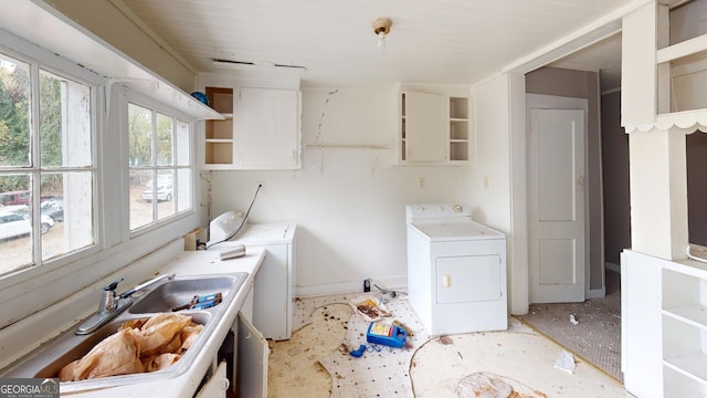 clothes washing area with washer / dryer, plenty of natural light, and sink