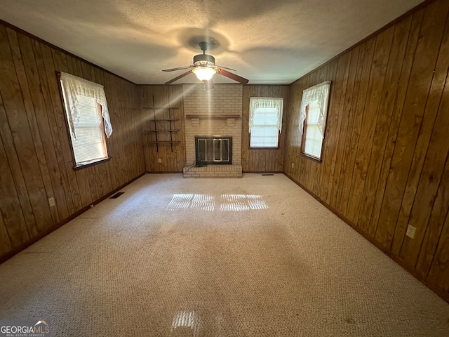 unfurnished living room with wood walls and a brick fireplace