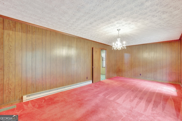 unfurnished room featuring a baseboard heating unit, carpet flooring, a notable chandelier, a textured ceiling, and wooden walls