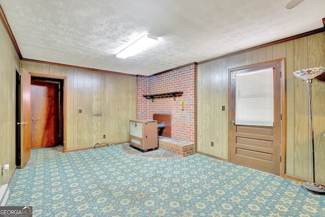 interior space with wooden walls, a textured ceiling, and ornamental molding