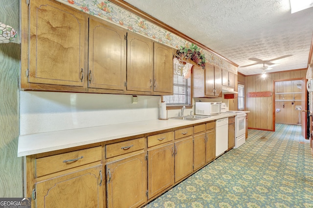 kitchen with a textured ceiling, white appliances, sink, and crown molding