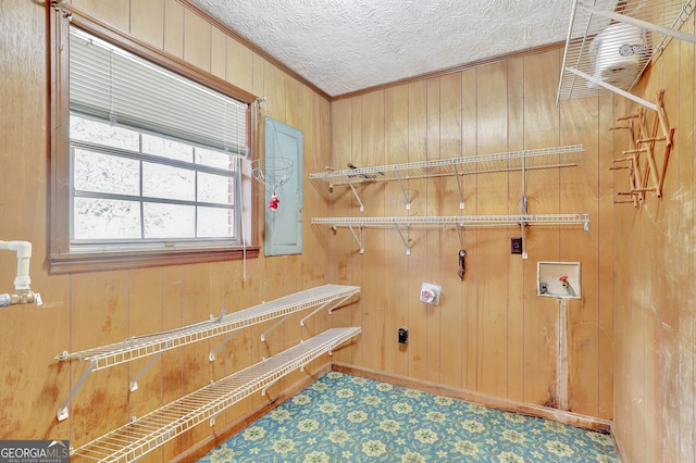 laundry area featuring a textured ceiling, washer hookup, wooden walls, and crown molding