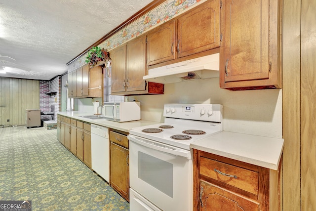 kitchen with ornamental molding, a textured ceiling, white appliances, and sink