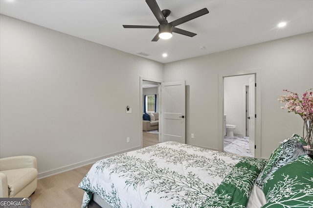 bedroom with ceiling fan, ensuite bathroom, and light hardwood / wood-style flooring