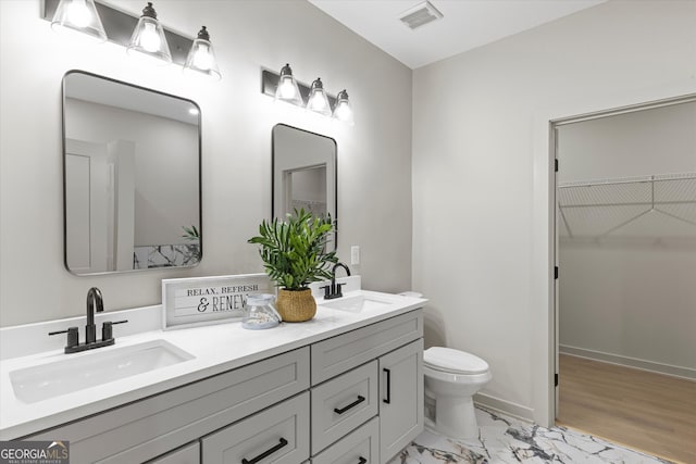 bathroom with hardwood / wood-style flooring, vanity, and toilet