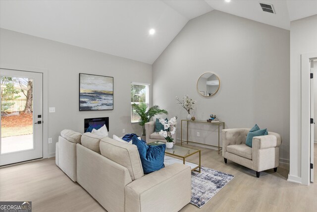 living room with light hardwood / wood-style flooring and lofted ceiling