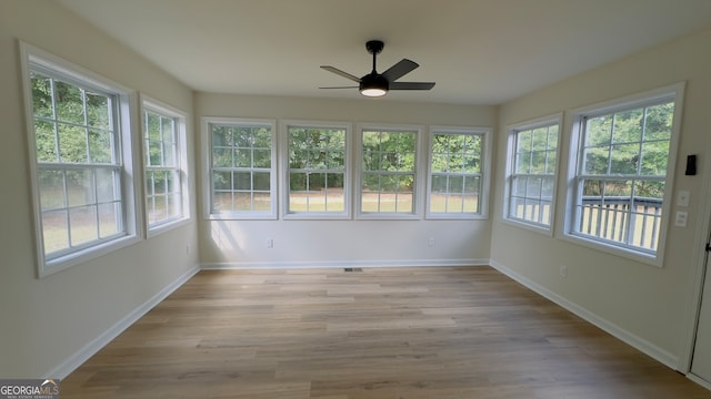 unfurnished sunroom with ceiling fan