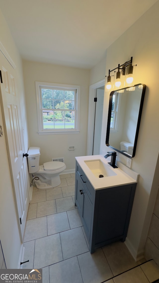 bathroom featuring toilet, vanity, and tile patterned floors