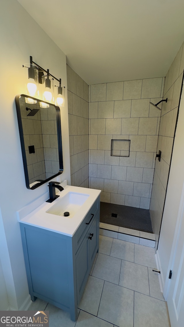 bathroom featuring vanity, tile patterned floors, tiled shower, and tile walls