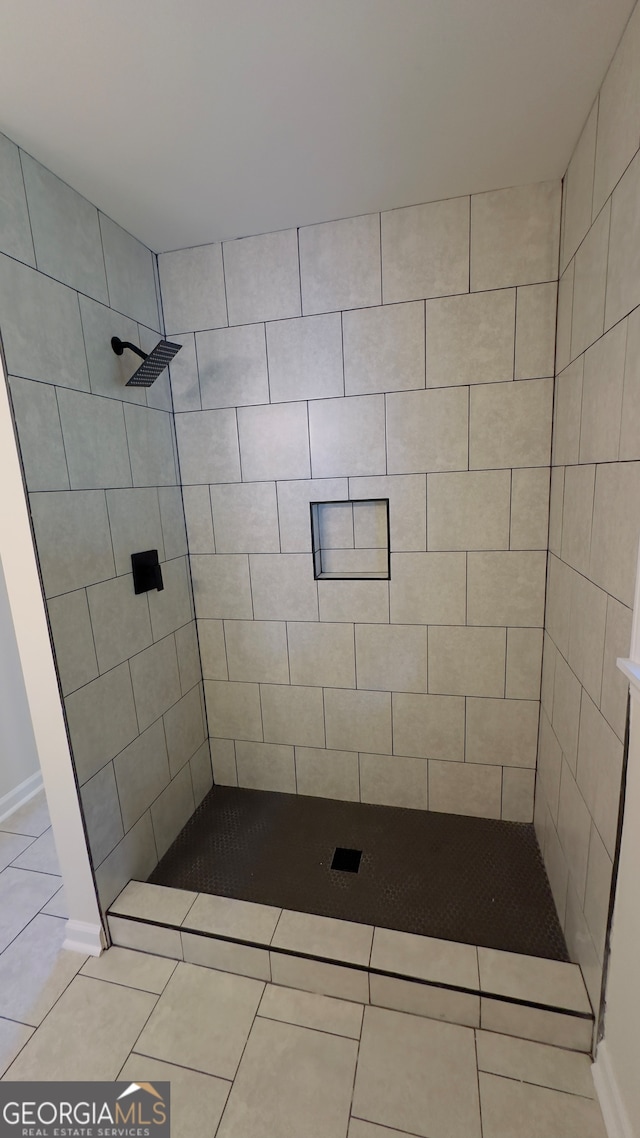 bathroom with tile patterned flooring and tiled shower