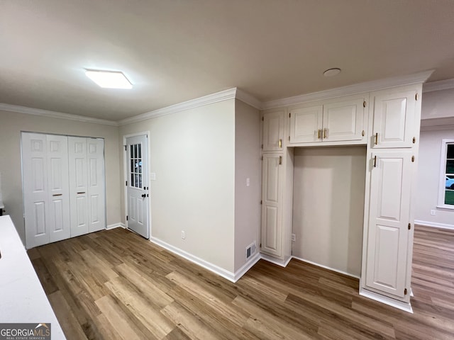 unfurnished bedroom with light wood-type flooring and crown molding