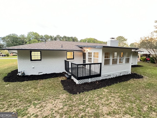 back of property featuring a deck and a yard