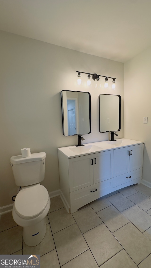 bathroom featuring toilet, vanity, and tile patterned floors