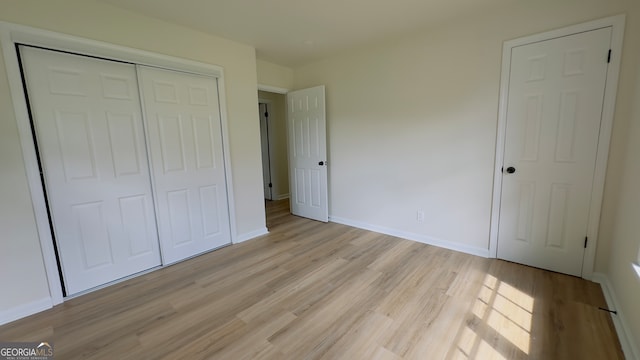 unfurnished bedroom with light hardwood / wood-style floors and a closet