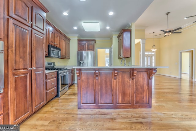 kitchen with crown molding, stainless steel appliances, a breakfast bar, light hardwood / wood-style floors, and ceiling fan