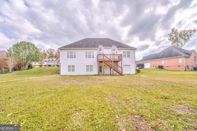 rear view of property with a wooden deck and a lawn