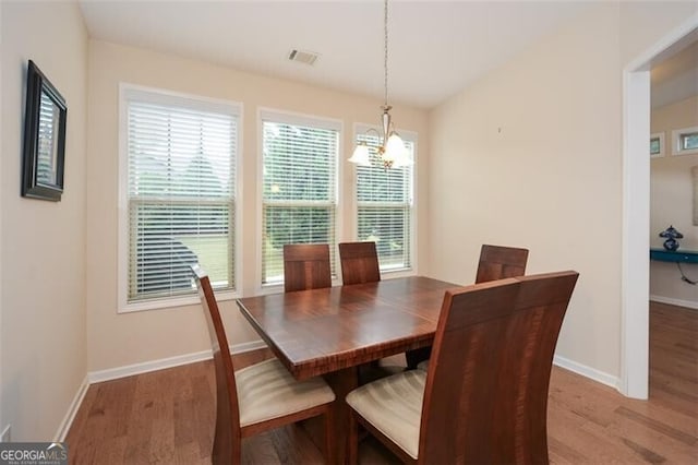 dining area featuring a chandelier and wood-type flooring