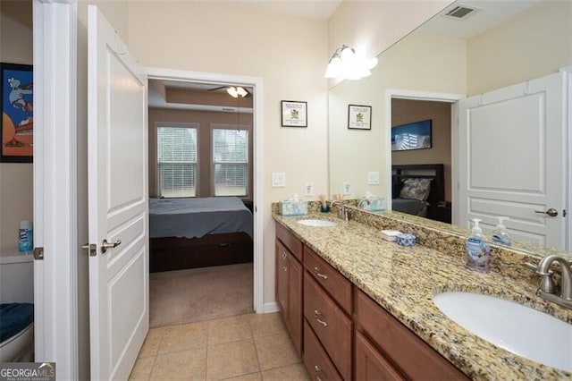 bathroom with toilet, vanity, tile patterned floors, and ceiling fan