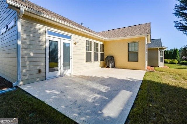 back of property with a lawn and a patio area