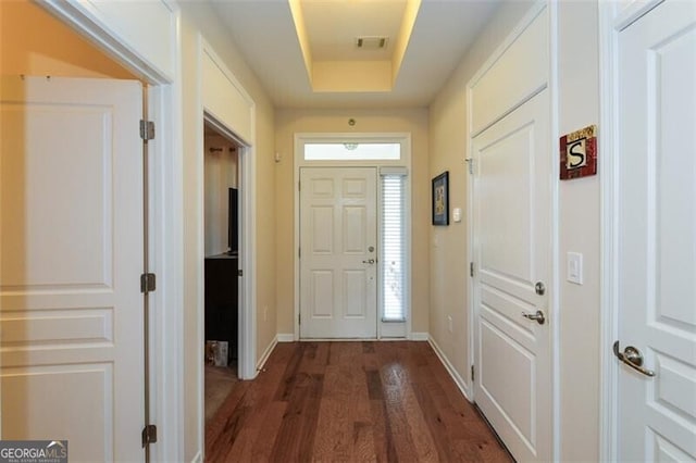 doorway featuring dark hardwood / wood-style flooring and a tray ceiling