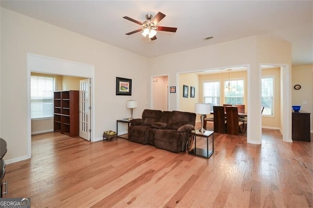 living room with wood-type flooring, ceiling fan, and plenty of natural light