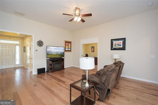 living room with light wood-type flooring and ceiling fan