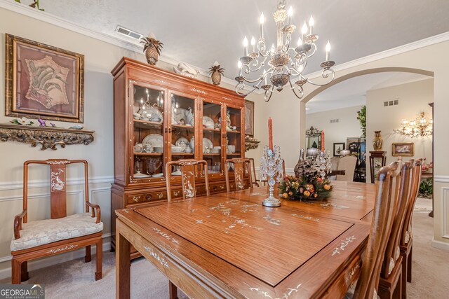 dining space with light colored carpet, crown molding, and an inviting chandelier