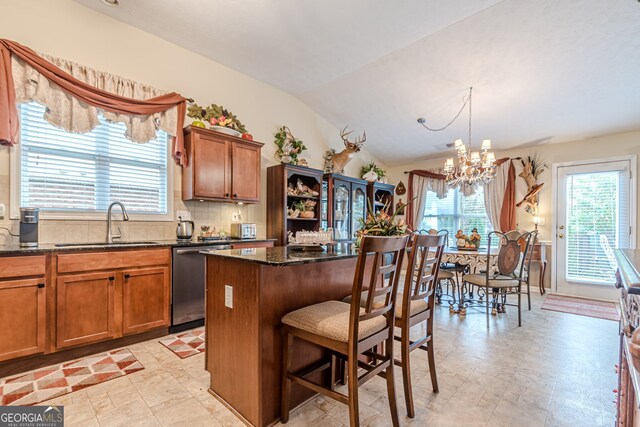 kitchen with dishwasher, a center island, vaulted ceiling, and plenty of natural light