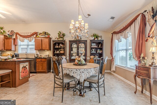 dining space featuring lofted ceiling, sink, and an inviting chandelier