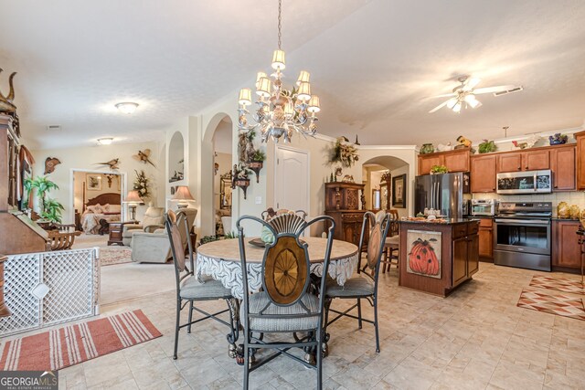 dining space featuring ceiling fan with notable chandelier and vaulted ceiling