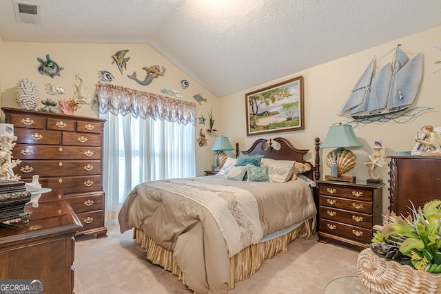 carpeted bedroom with a textured ceiling and vaulted ceiling