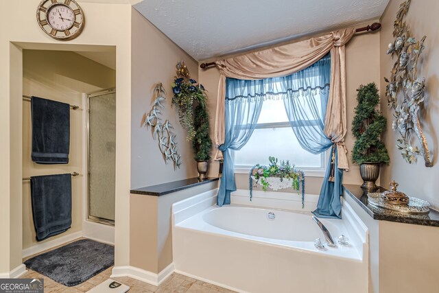 bathroom featuring a textured ceiling and separate shower and tub