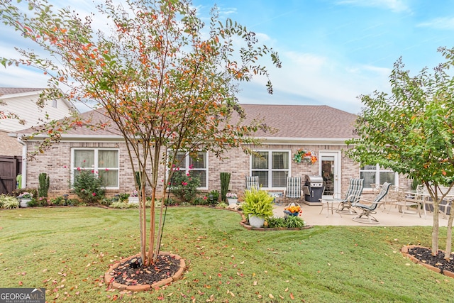 back of property with a yard and a patio area