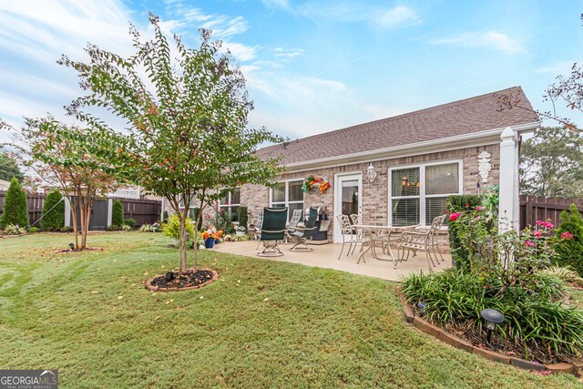 back of house featuring a lawn and a patio area