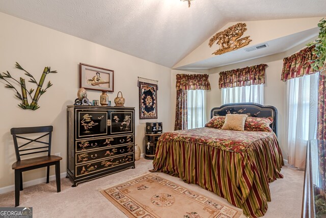 carpeted bedroom with a textured ceiling and vaulted ceiling