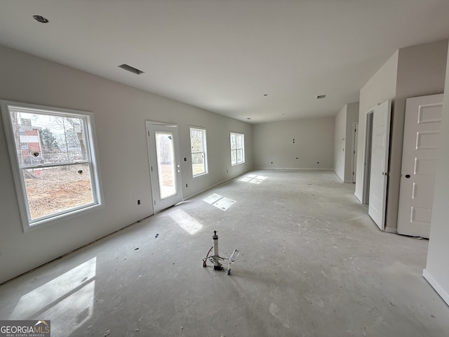 unfurnished living room featuring visible vents