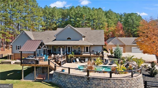 rear view of property featuring a pool side deck and a lawn