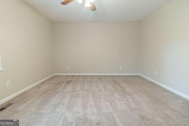 spare room featuring light colored carpet and ceiling fan