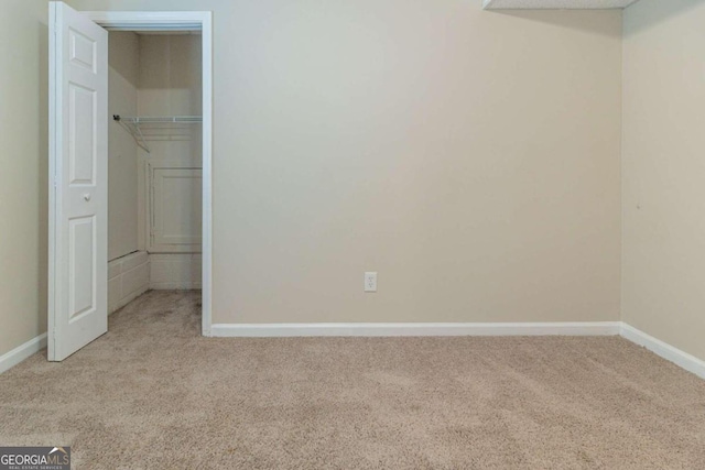 unfurnished bedroom with light colored carpet and a closet